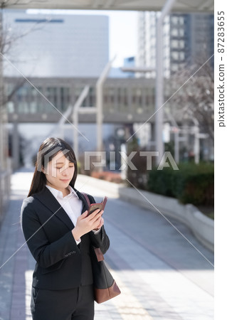 Business image of a woman looking at a smartphone Business image of a woman looking at a smartphone 87283655