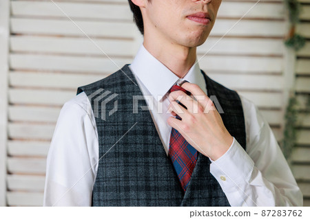 A man wearing a vest that touches a tie (no face) A man wearing a vest that touches a tie (no face) 87283762