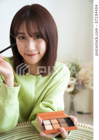 Woman doing make-up Woman doing make-up 87284484