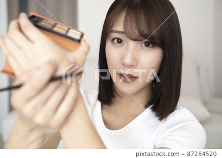 Woman doing make-up Woman doing make-up 87284520