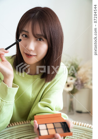 Woman doing make-up 87284544