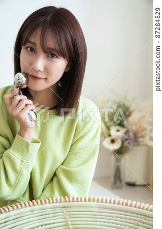 Woman doing facial roll Woman doing facial roll 87284829
