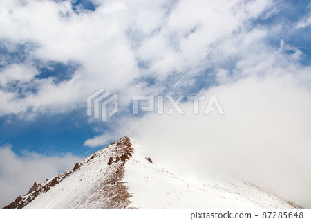 High snowy mountain range with blue sky background with copy space 87285648