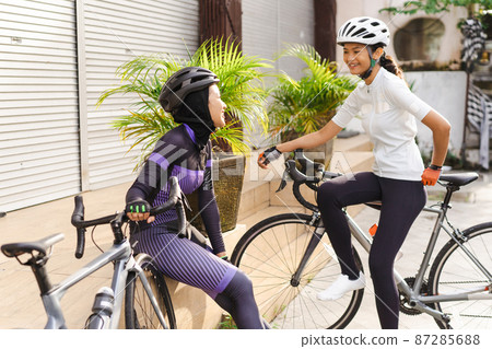 muslim cyclist take a break and having conversation on a road side 87285688