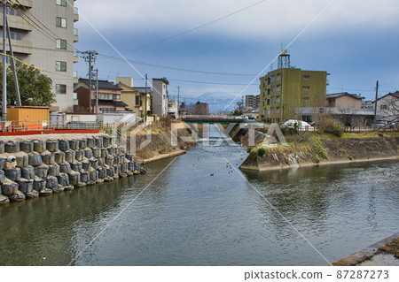 在富山縣富山市赤町的橋和松川上看到的北阿爾卑斯山 87287273