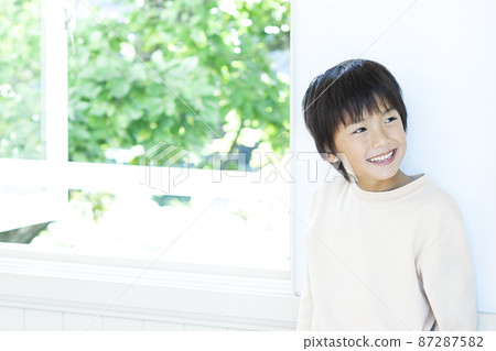 站立在窗台的微笑的男孩 87287582
