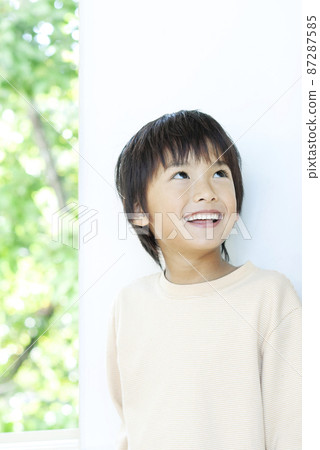 站立在窗台的微笑的男孩 87287585