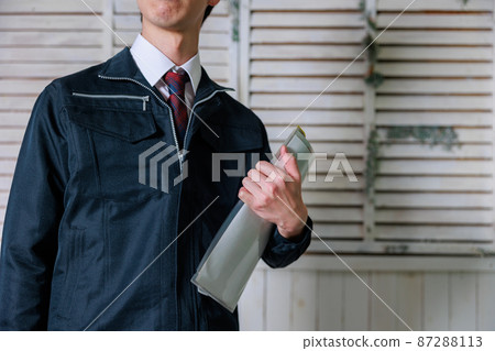Man in work clothes with documents (no face) Man in work clothes with documents (no face) 87288113