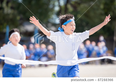 Elementary school boy who wins the first prize in a foot race 87288366