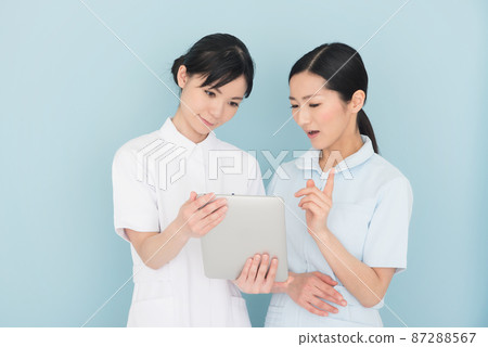 看平板設備的兩名女護士 看平板設備的兩名女護士 87288567