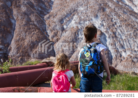 Soligorsk mountains. potash plant. children travel with backpacks on the back Soligorsk mountains. potash plant. children travel with backpacks on the back 87289281