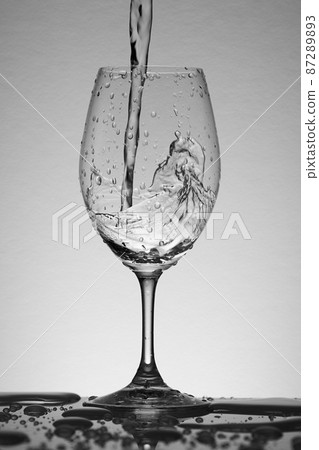 Water poured vigorously into a wine glass Water poured vigorously into a wine glass 87289893