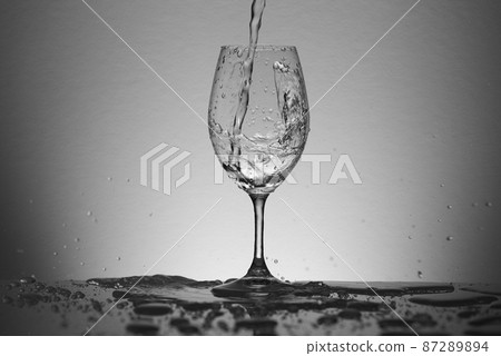 Water poured vigorously into a wine glass Water poured vigorously into a wine glass 87289894