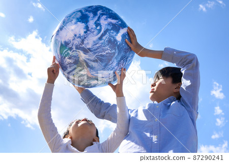 Children playing with a ball with an earth pattern 87290241