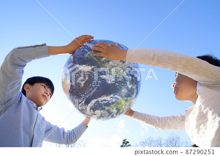 Children playing with a ball with an earth pattern 87290251