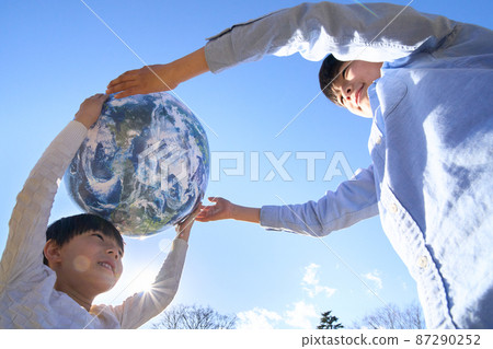 Children playing with a ball with an earth pattern 87290252