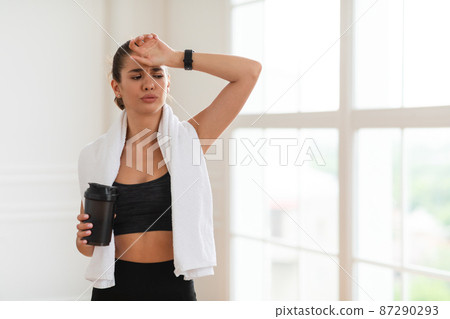 Portrait of sporty beautiful smiling woman holding shaker Portrait of sporty beautiful smiling woman holding shaker 87290293