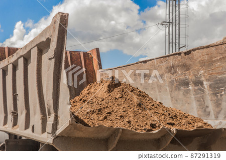 Dump truck with a pile of sand in the back construction washed earthworks on site 87291319