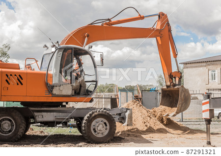 Excavator digging heavy earth work on an industrial machine on a construction site industry Excavator digging heavy earth work on an industrial machine on a construction site industry 87291321