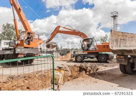 Excavator digging heavy earth work on an industrial machine on a construction site industry Excavator digging heavy earth work on an industrial machine on a construction site industry 87291323