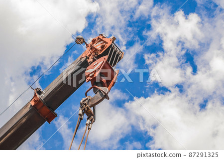 Lifting hoisting mechanism with rope steel of the machine bridge crane with iron cable and hook on a blue sky background 87291325