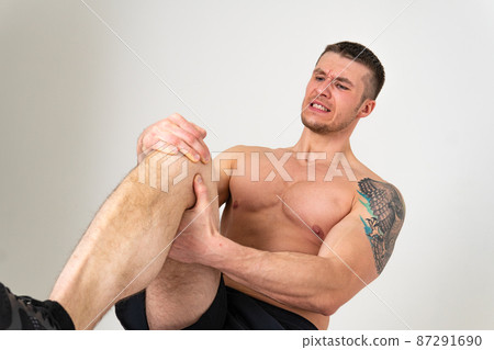 A man's kneecap hurts on a white background pain sore muscle, backache spine white medical, human expression. Hold red back suffer attractive 87291690