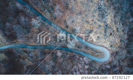 Narrow road in misty forest, aerial view. 87292127