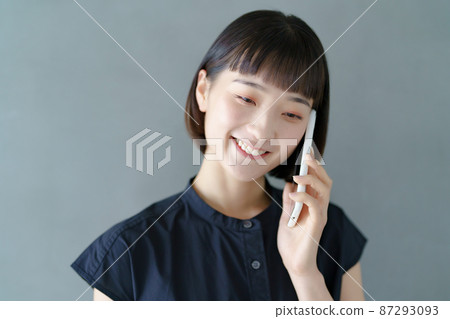 A woman talking on a smartphone 87293093