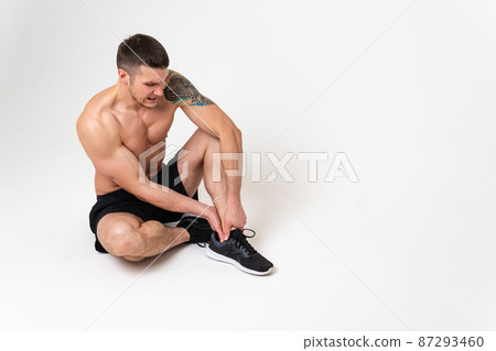 A man's kneecap hurts on a white background ache sore painful, ill male young stress, human holding. Tension neck sickness, lower suffer attractive A man's kneecap hurts on a white background ache sore painful, ill male young stress, human holding. Tension neck sickness, lower suffer attractive 87293460