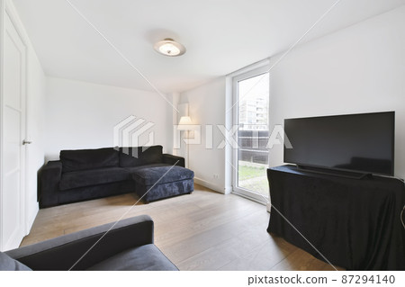 Minimalist living room with black sofa and TV Minimalist living room with black sofa and TV 87294140