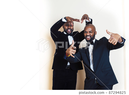 two african-american businessmen in black suits emotional posing, gesturing, smiling. wearing bow-ties 87294825