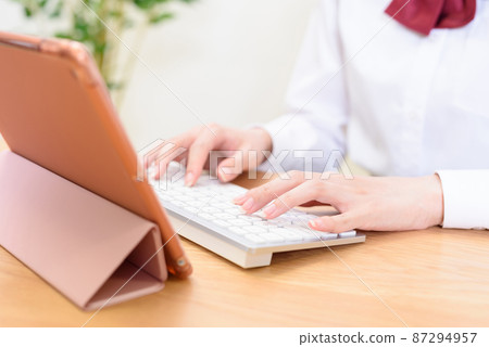 High school girls studying while typing on a tablet terminal with a keyboard Online class Touch typing High school girls studying while typing on a tablet terminal with a keyboard Online class Touch typing 87294957