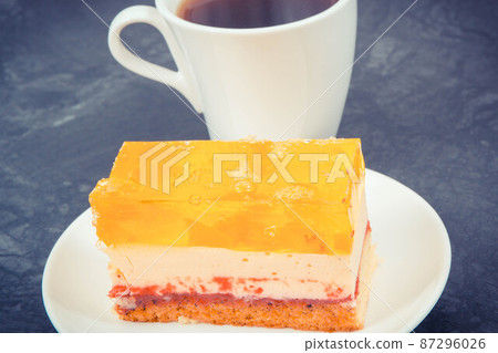 Creamy fruit cake with jelly and cup of coffee for different occasions. Festive dessert 87296026