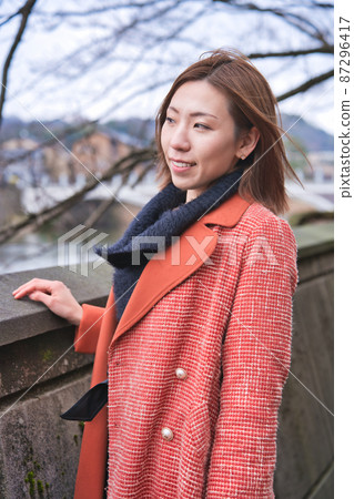 A young woman taking a walk along the river in Kanazawa A young woman taking a walk along the river in Kanazawa 87296417