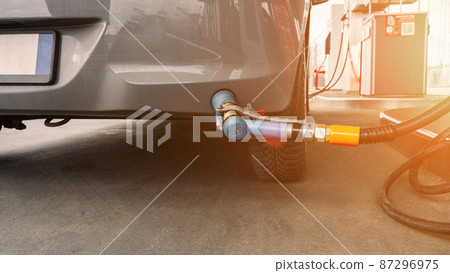 Gas station. Pump fuel petrol in tank car. Gasoline oil in nozzle. Close-up of the hand and the fuel gun. Blurred background. Gas station. Pump fuel petrol in tank car. Gasoline oil in nozzle. Close-up of the hand and the fuel gun. Blurred background. 87296975