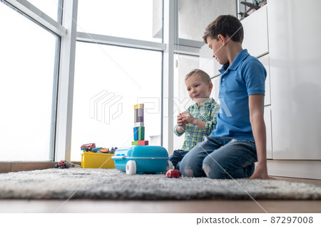 Concentrated little boy building a construction structure 87297008