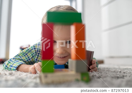 Smiling happy kid playing with the construction set Smiling happy kid playing with the construction set 87297013