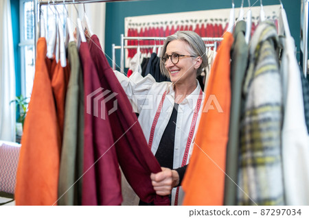 Woman looking at dress standing near counter 87297034