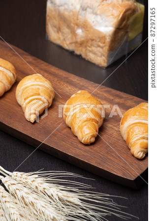 Fresh croissants on a wooden board. Freshly baked in morning. 87297165