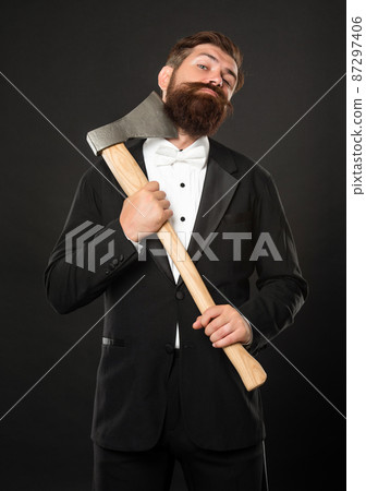 Bearded man scraping chin with axe dark background, barbering Bearded man scraping chin with axe dark background, barbering 87297406