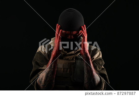 photo of a man in a military uniform and balaclava with a bloody face and hands up to the elbow in blood on a black background photo of a man in a military uniform and balaclava with a bloody face and hands up to the elbow in blood on a black background 87297887