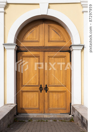 Old wooden door in yellow wall, background texture Old wooden door in yellow wall, background texture 87297959