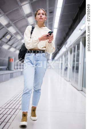 Young european female with mobile waiting the metro 87298049