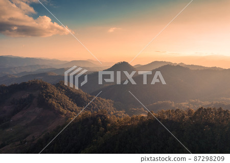 Aerial view of beautiful sunset over mountain range in tropical rainforest on faraway countryside at national park 87298209