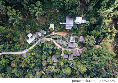 Aerial view of local rural village with gravel road through in the valley on faraway at countryside among the tropical rainforest 87298229