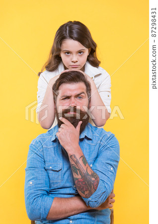 Father is idol of each child. Little daughter hug serious father. 87298431