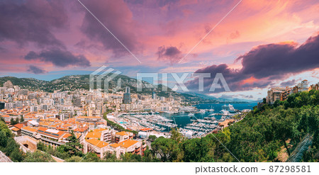 Monaco, Monte Carlo cityscape. Real estate architecture on mountain hill background. Many high-rise buildings in downtown area. Yachts moored at town quay In Sunny Summer Day. Altered Sunset Sky Monaco, Monte Carlo cityscape. Real estate architecture on mountain hill background. Many high-rise buildings in downtown area. Yachts moored at town quay In Sunny Summer Day. Altered Sunset Sky 87298581