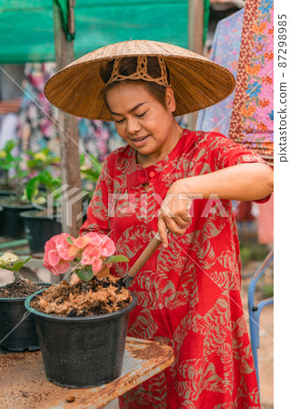 Happy Woman Planting Flowers At Her Backyard Stock Photo