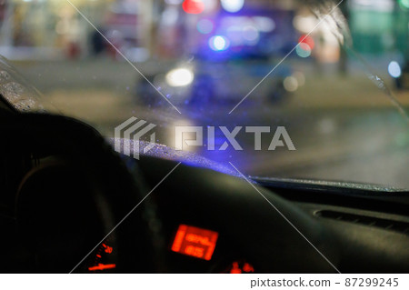blurry steering wheel and car dashboard with blurred night street background 87299245