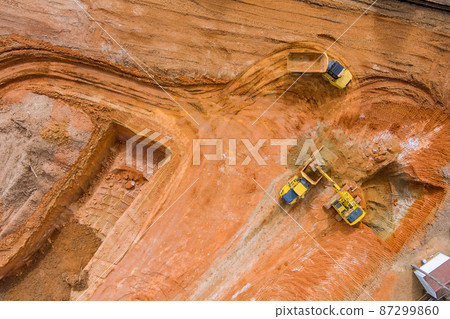 Aerial view of excavator loading the tipper truck at the construction site Aerial view of excavator loading the tipper truck at the construction site 87299860
